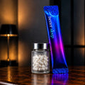 A blue and purple iridescent stick pack labeled 'better sleep' stands next to a small clear jar filled with white capsules on a dark wooden table, with warm ambient lighting in the background.